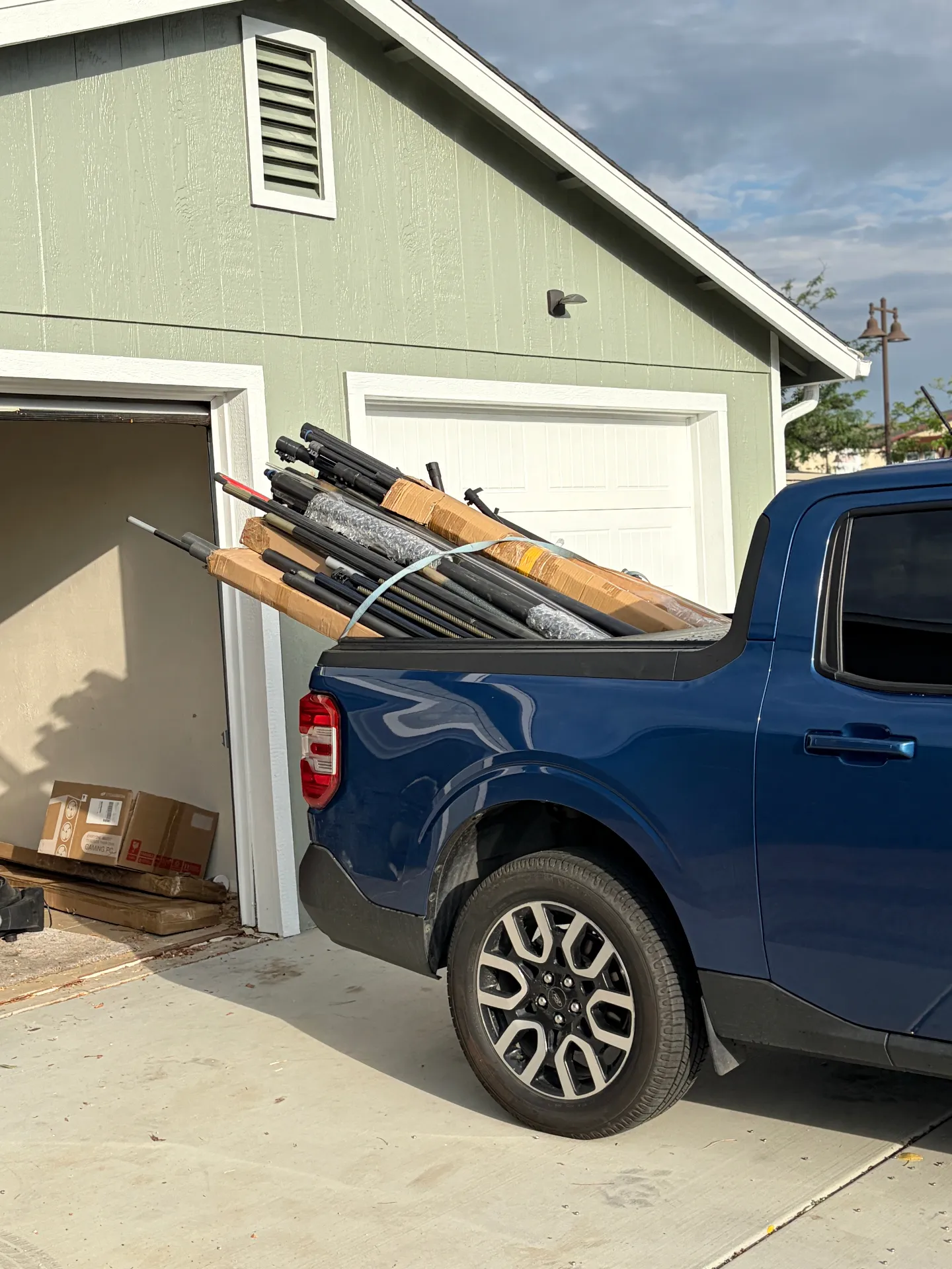 Blue pickup truck bed loaded with bundled carbon fiber water fed pole sections and packaged accessories ready for delivery