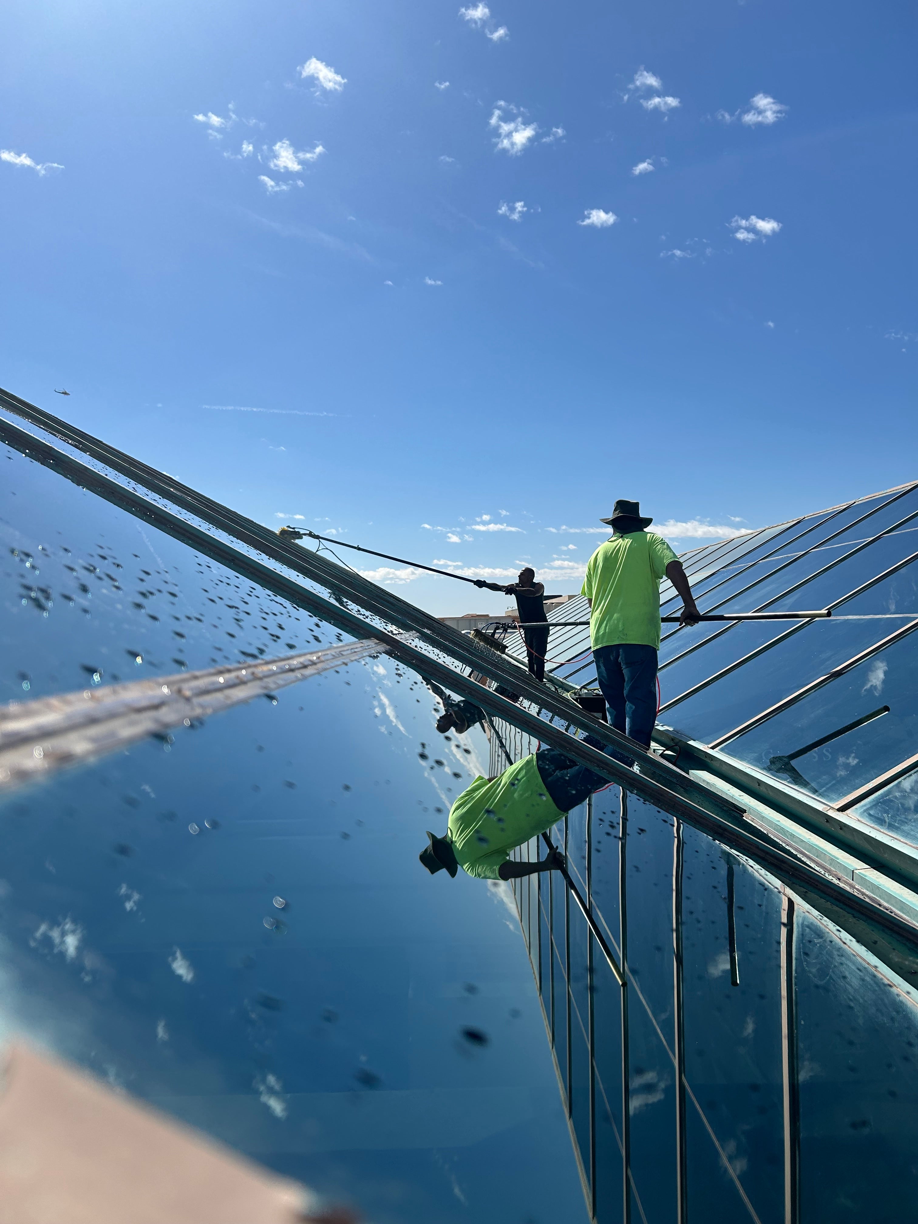 Water fed pole and brush cleaning a glass roof